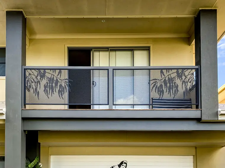 An upstairs balcony on a Queensland townhouse with Gum Perf balustrade panels showing gum leaves