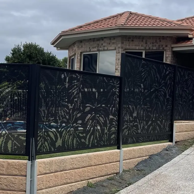Black Monstera Perf panels on top of a sandstone-look retaining wall in Queensland, with the pool visible through them