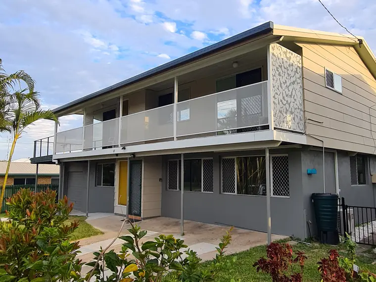 A two-storey Queensland home with a pale Surfmist PurePerf balustrade along the upstairs balcony and a patterned feature panel at the end