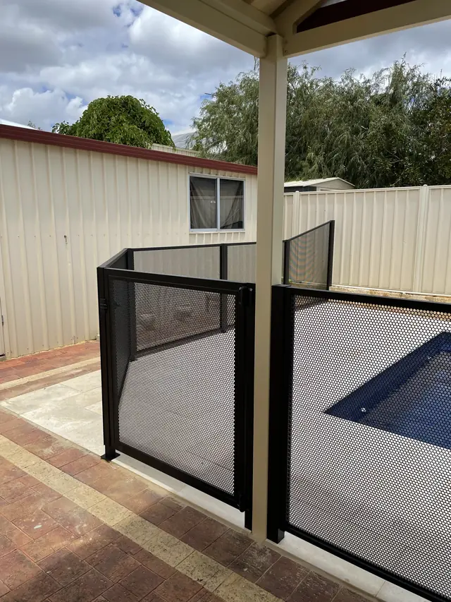 A black PurePerf pool fence under a patio, beside a small pool