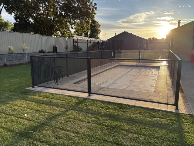 A Monument PurePerf fence around a covered pool at sunset