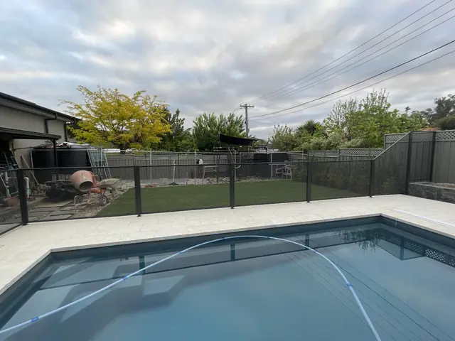 A Monument PurePerf fence behind a pool, with the garden seen through it