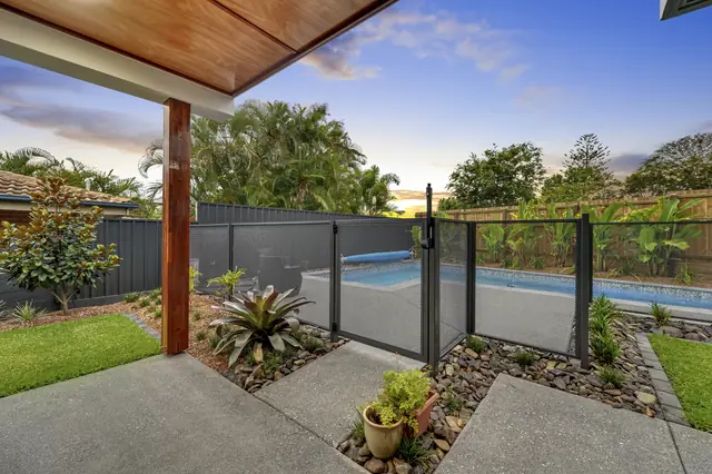 A Monument PurePerf fence and gate beside a lap pool at dusk