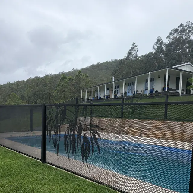 A black Gum Perf design panel, with a pool and a house on the hill behind