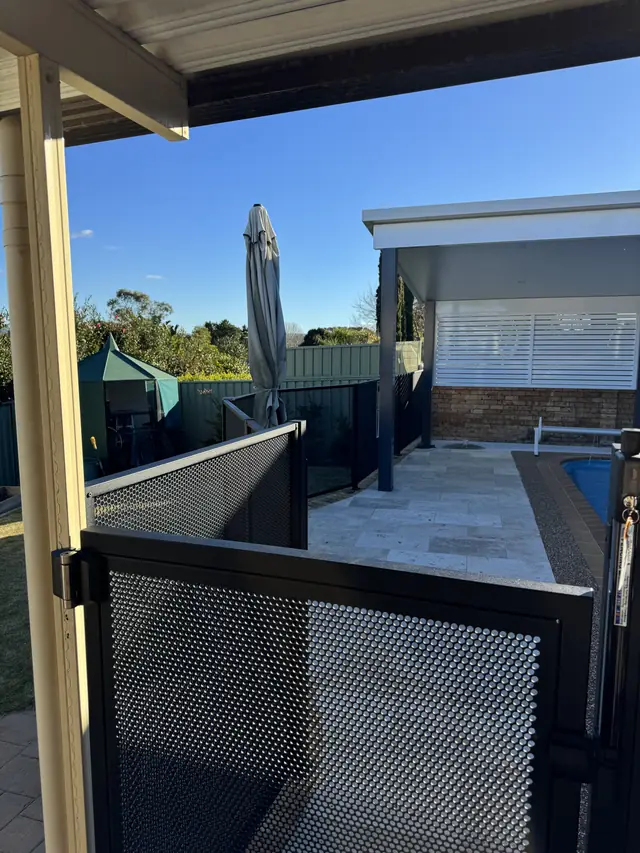 Looking out from a patio through a black PurePerf fence and gate