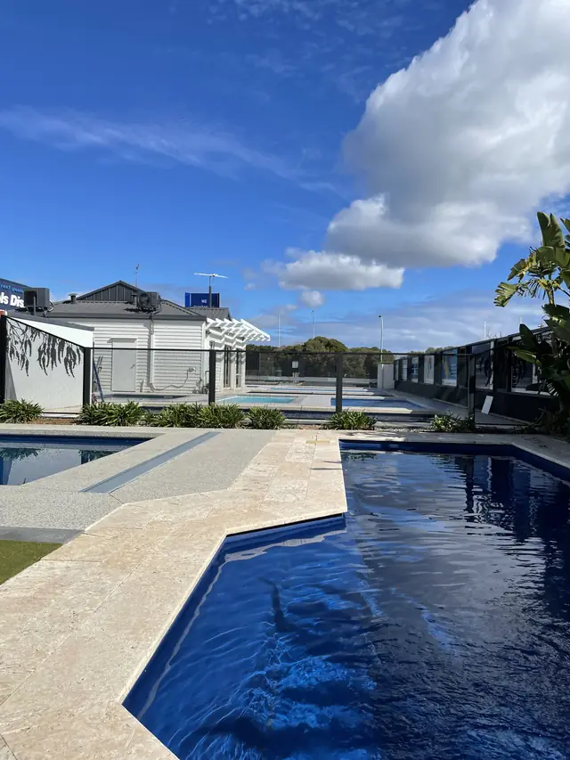 A black PurePerf fence at the end of a long, dark blue pool