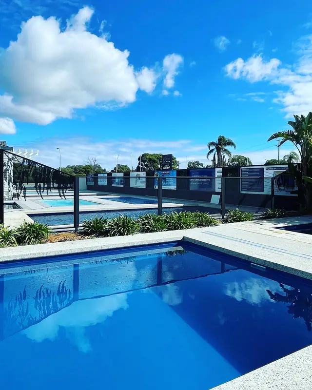 A black PurePerf fence reflected in a deep blue pool