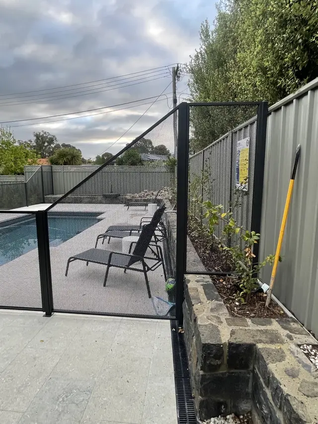 A Monument PurePerf fence beside a pool and a garden bed