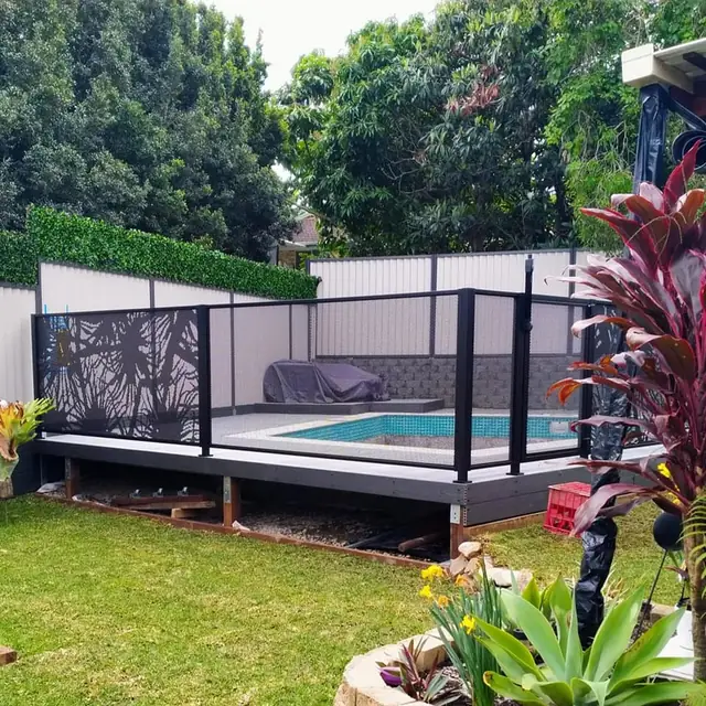 A black Pandanus Perf design pool fence on a raised deck
