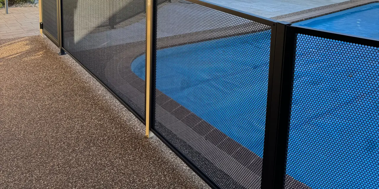 Close up of a black PurePerf panel, with a blue pool seen through the holes