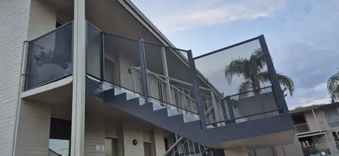 Grey PoolPerf balustrade panels following an outdoor staircase up to a landing on an apartment building