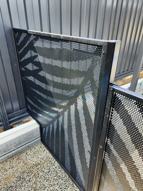 Close up of a black Palmy design PoolPerf panel with a step cut out of its bottom corner to clear a concrete edge