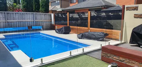 Banana leaf panels set into a timber screen wall at the back of a Victorian pool, with glass across the front