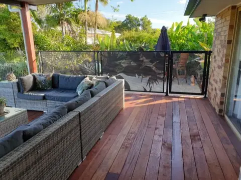 Banana in Paradise panels around a timber deck with an outdoor lounge, the garden beyond