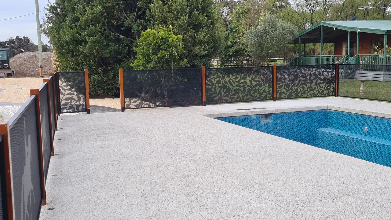 Black Ficus design panels between timber posts around a Victorian pool on a lawn