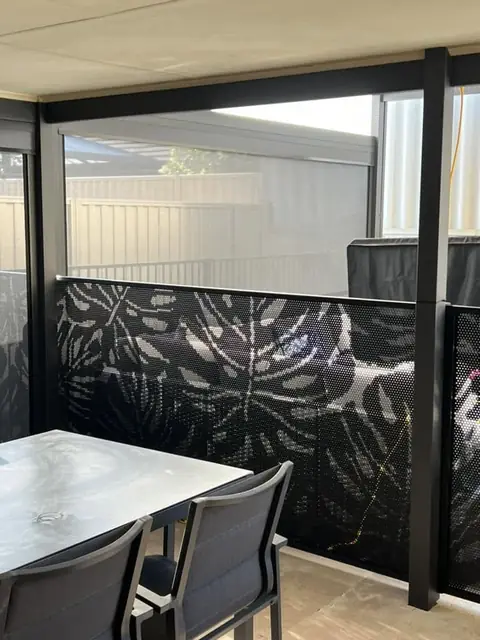 Black Monstera 2 design panels beside an outdoor dining table under a patio