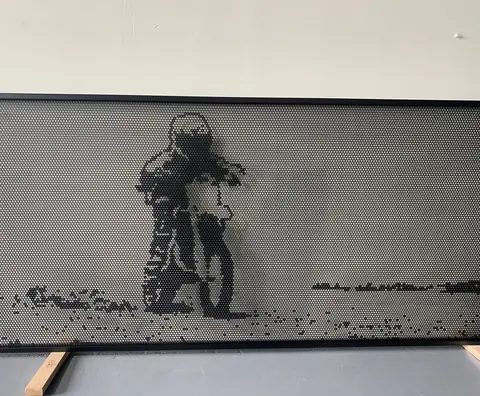 A motorbike rider cut into a grey perforated panel