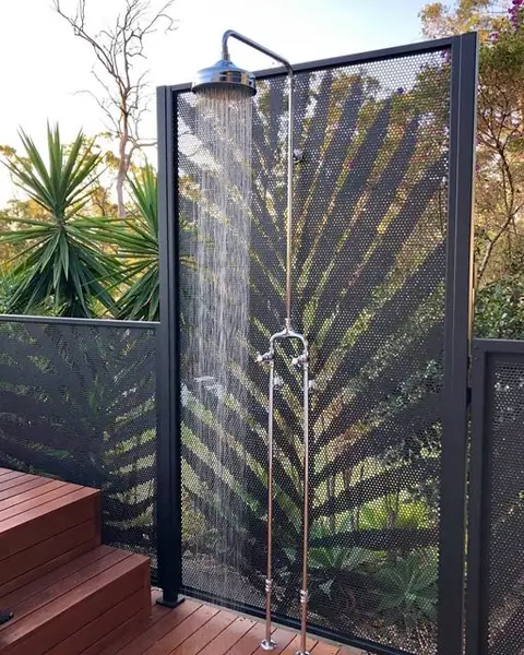 A black Palm design panel behind an outdoor shower beside a pool deck in Queensland