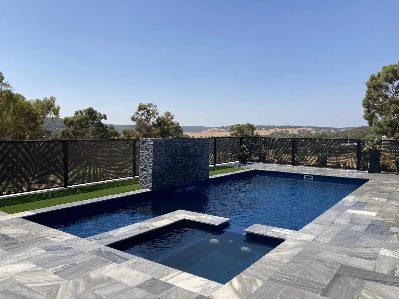 Black Palmy design panels around a pool and spa in Western Australia, looking out over open country
