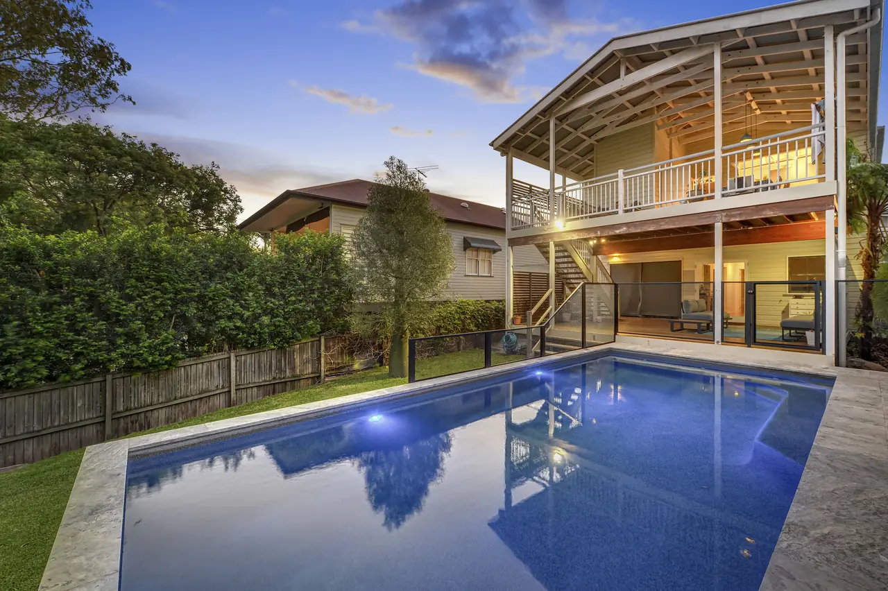 A black PurePerf fence around a pool beside a modern two storey Queensland home