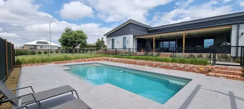 A long black PurePerf fence running the length of a lap pool in a Victorian backyard