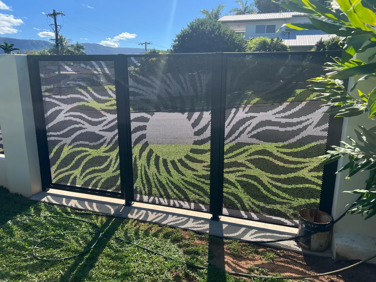 A black Sun Rays design gate and fence, the rays spreading from a sun cut low in the panel