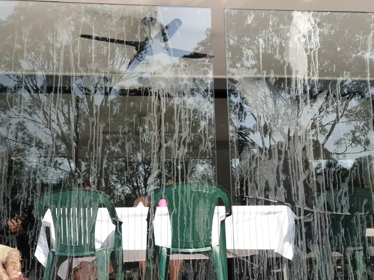 A close-up of the same glass panel, covered in dried water streaks