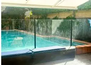 A glass pool fence covered in streaks and water marks after the school holidays