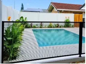 A black PoolPerf fence in front of a backyard pool on the day it was installed