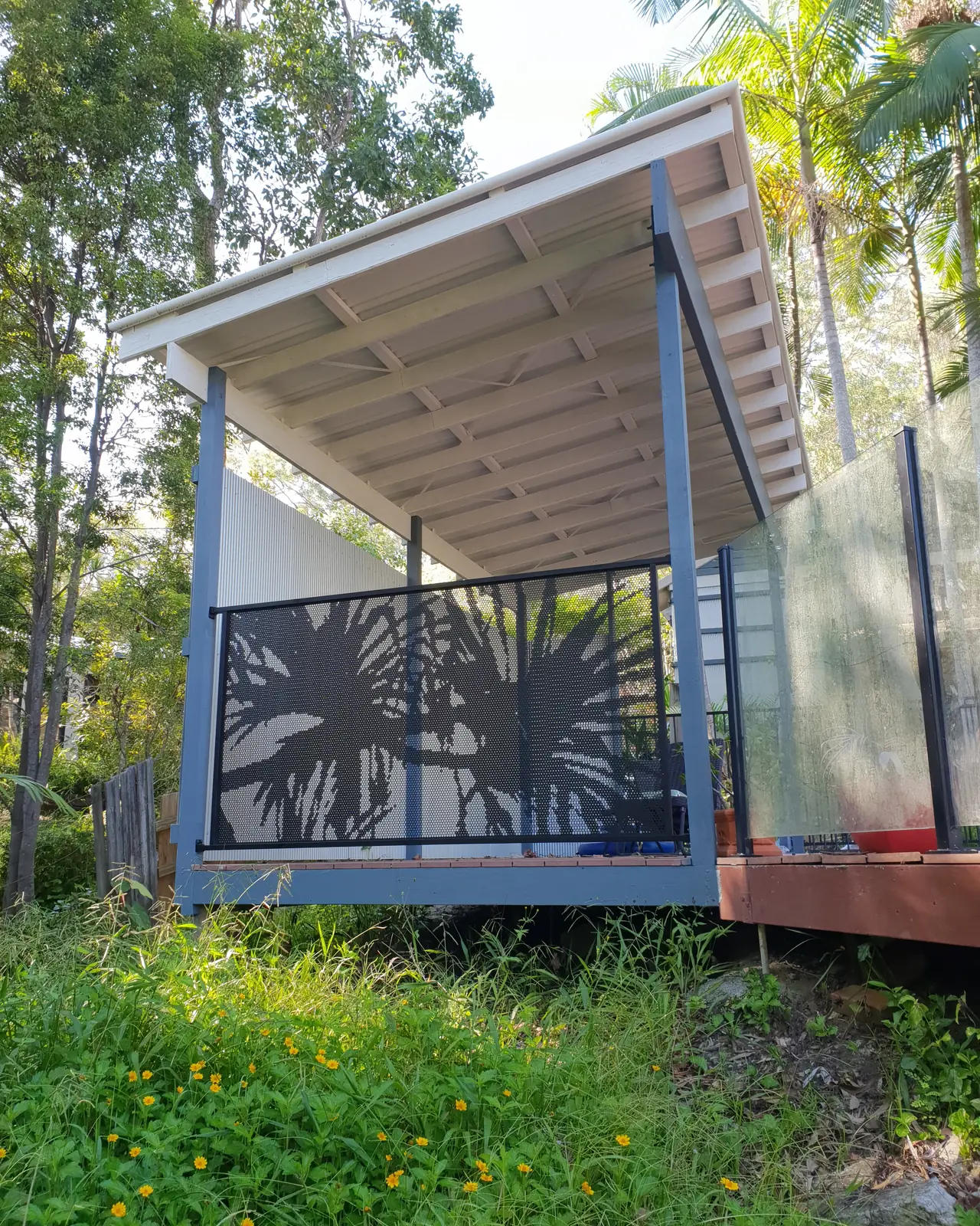 A black Pandanus Perf design panel on a raised deck next to a dirty glass panel, with the glass now harder to see through than the design