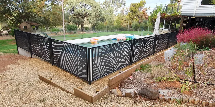 Black Palmy design PoolPerf panels around a pool, with glass along the far side