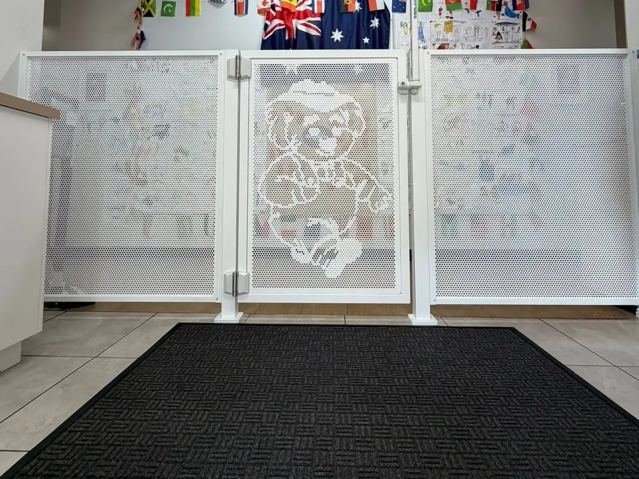 White perforated panels and a gate with a custom koala design inside a childcare centre