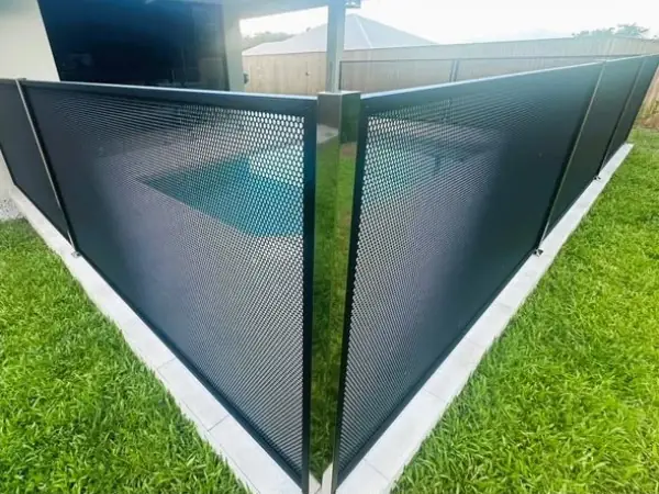 Two black PurePerf panels meeting at a corner beside a lawn, joined by a mirror finish stainless steel post
