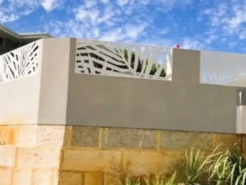 White leaf design panels fixed along the top of a rendered wall to make it taller