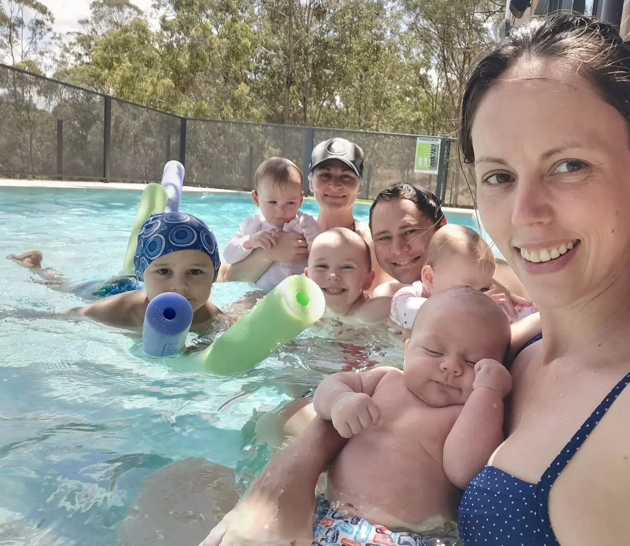 The founder's wife in the family pool with their five children, including a newborn