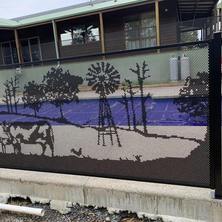 A one-off black PoolPerf panel showing a farm scene: a windmill, cattle and gum trees, with the pool behind it