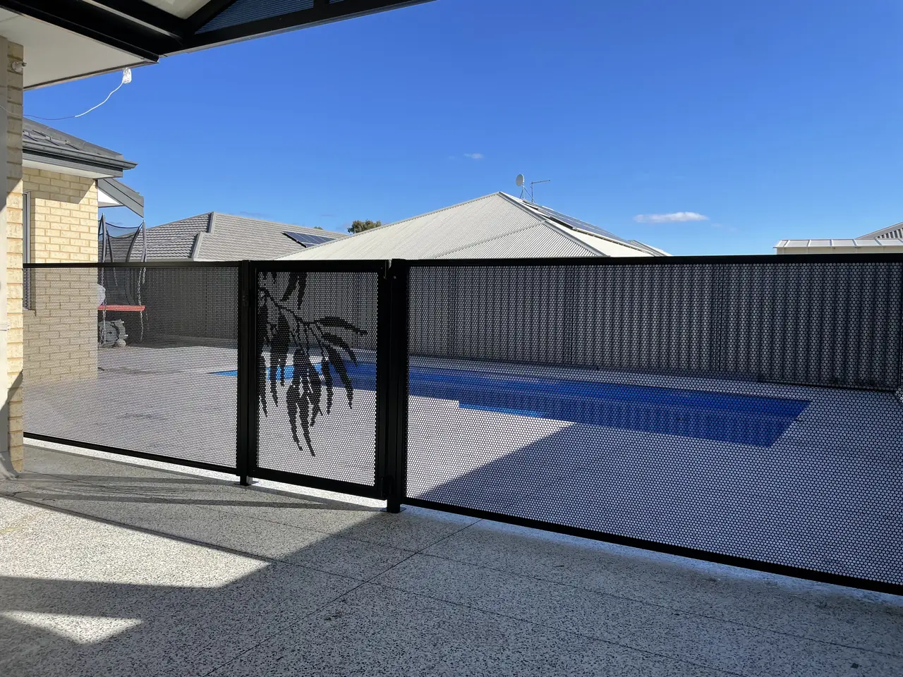A Gum design gate in a long black PurePerf pool fence beside a lap pool in Western Australia