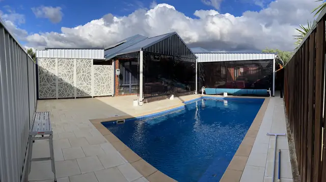 White patterned panels at the end of a long blue pool