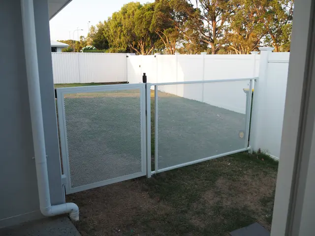 A white Pure Perf fence and gate beside a white boundary fence