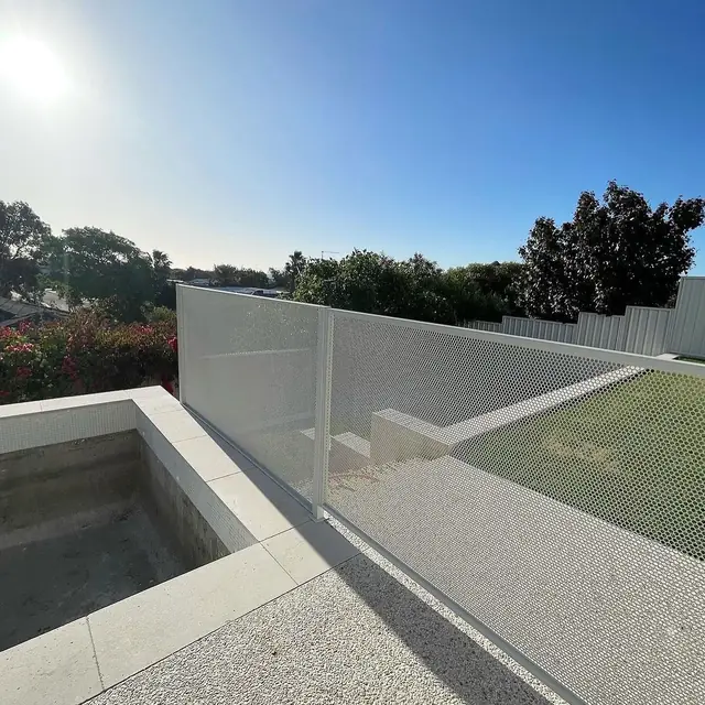 A white Pure Perf fence running along a raised pool edge