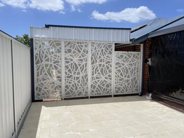 White patterned panels closing off a paved courtyard