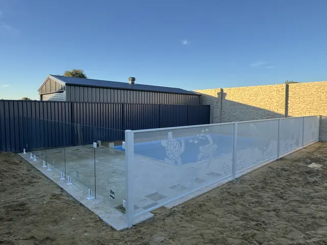 A white sea-creature design pool fence around a new pool