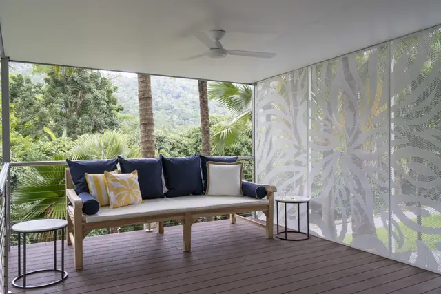 A white patterned screen on a covered deck with a view to the hills