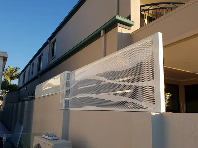 A white Wave design privacy screen on the side of a house